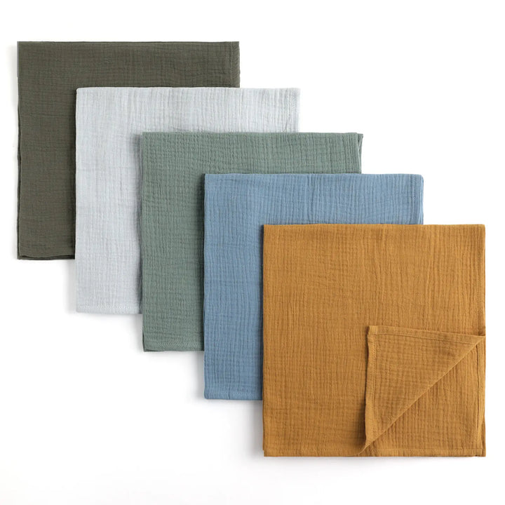 Set of 5 Organic Cotton Muslin Swaddle Blankets laid out in Mustard, Blue, Sage, Grey, and Olive colors, ideal for newborns and infants.